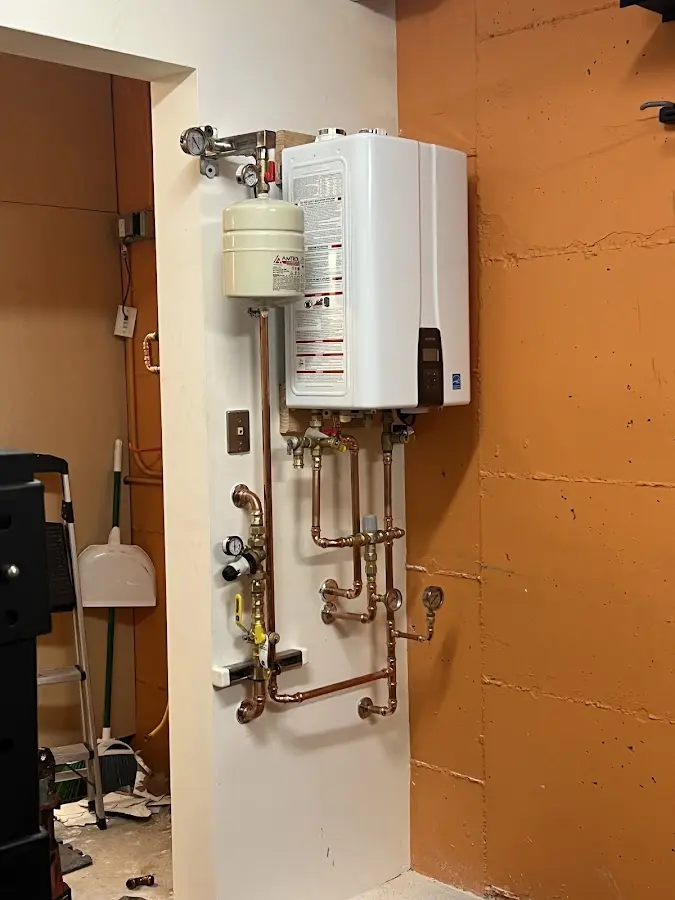 Plumbing technician inspecting water heater connections in Norcross